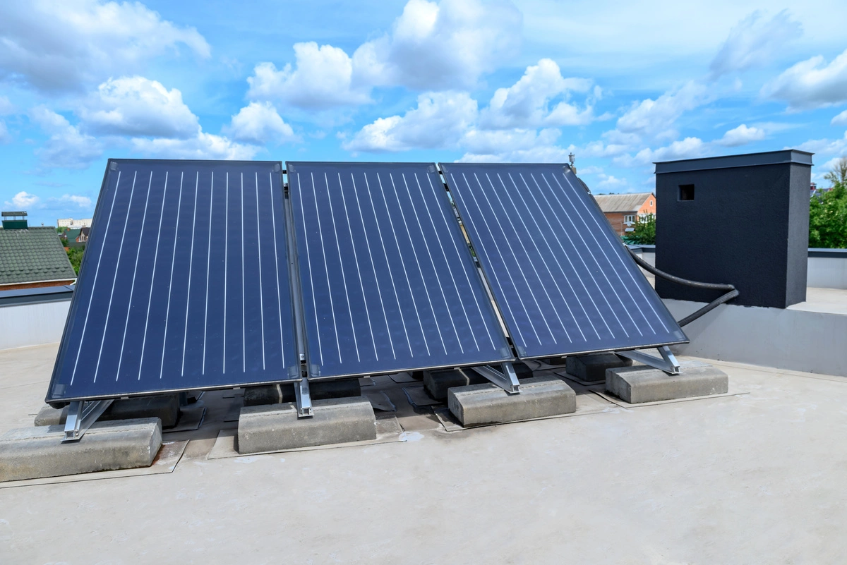 Panneaux solaires thermiques installés sur le toit d'un bâtiment sous un ciel bleu