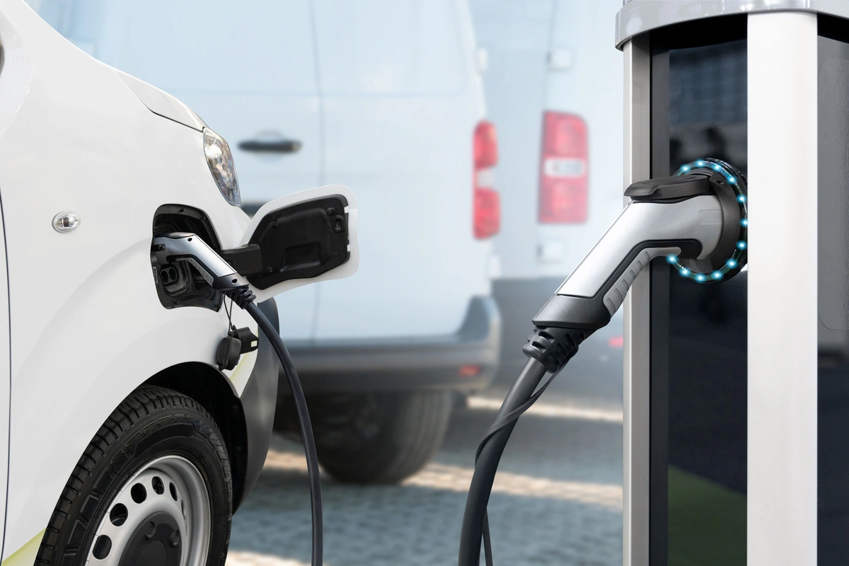 Véhicule utilitaire électrique en cours de recharge avec une borne de recharge