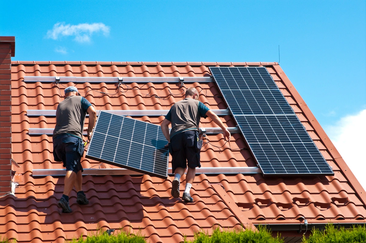 Installation de panneaux photovoltaïques sur un toit en tuiles par des techniciens